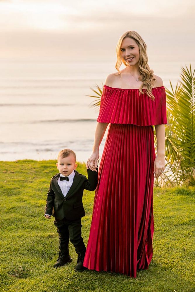 Fashion blogger, Christina Chitwood, in a maxi dress holding hands with her toddler son. Womens Fashion Amazon Maxi Dress, Circus by Sam Edleman Booties, Nadri Earrings. Boys Hope and Henry Tuxedo