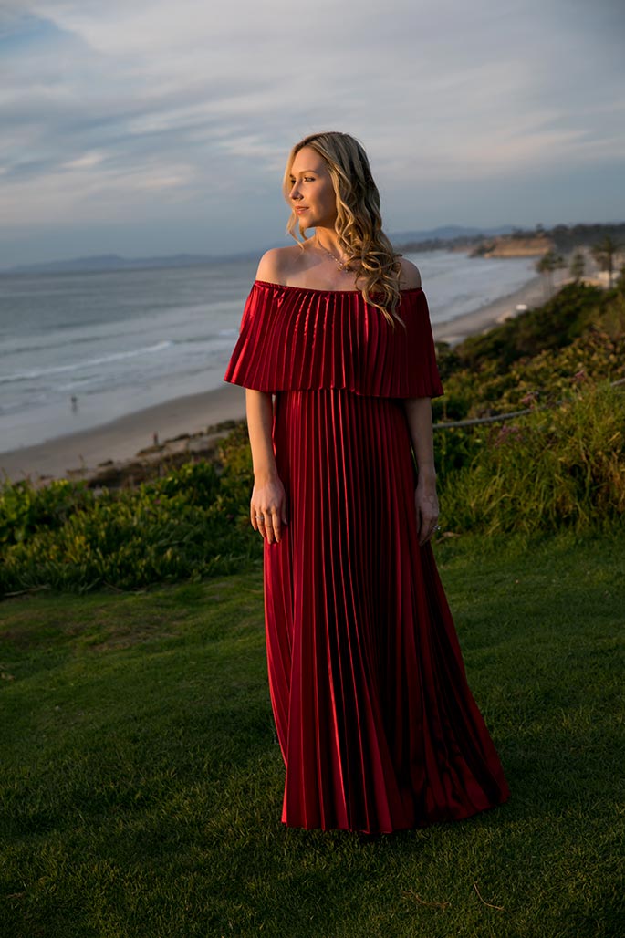 Fashion blogger, Christina Chitwood, looking out at the ocean in metallic red maxi dress. Womens Fashion Amazon Maxi Dress, Circus by Sam Edleman Booties, Nadri Earrings